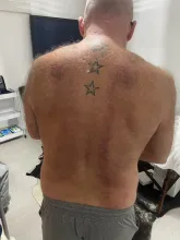 Client stood with his back to the camera in my studio and wearing no tshirt