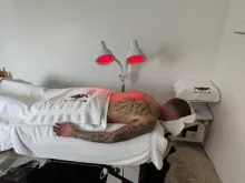 Client with angel wings tattoo face down on my massage bed and towel over bottom half of body